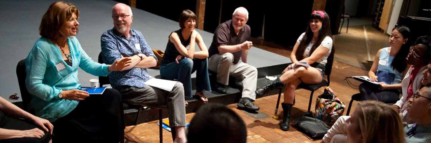 faculty and students seated in a stage setting in discussion